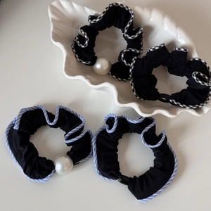 Gros plan de chouchous à perles avec motifs à carreaux noir et blanc et rayures bleues