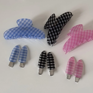 Close-up of blue, black, and pink gingham check pattern hair claws and barette clips set