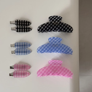 Detail showing classic plaid hair claw clips and bobby pins in black blue and pink set