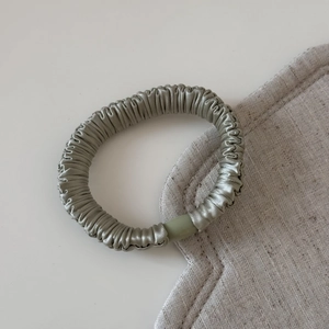 Gros plan détaillé du chouchou en satin avec boucle mate sur fond de tissu blanc élégant