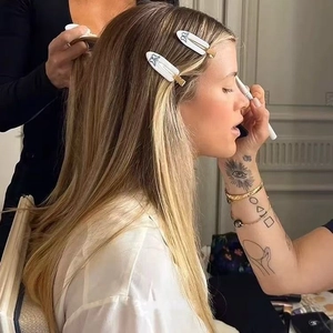 Detail showing two white acetate hair clips with butterfly prints on blonde hair