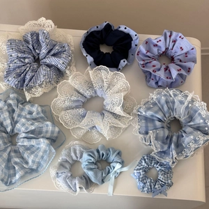 Detailed close-up showing nine assorted blue aesthetic scrunchies in various plaid patterns