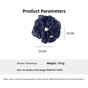 Detail of navy polka dot ruffle scrunchie with dimensions 22cm and fabric texture