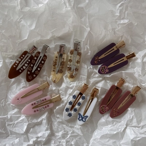 Detailed view of french marble pattern acetate hair clips with rhinestones and pearls