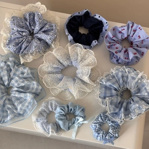 Detailed set of blue and white scrunchies in plaid, floral and lace patterns