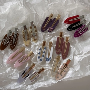 Close-up of French acetate hair clips with marble patterns and sparkling rhinestones