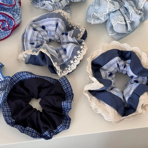 Detail view of blue plaid and lace scrunchie collection with assorted patterns on white