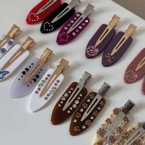 Detail showing various marble pattern acetate hair clips with inlaid rhinestones and patterns