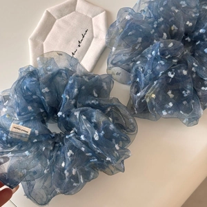 Détail de chouchous en tulle bleu avec pois blancs et étiquette de marque artisanale