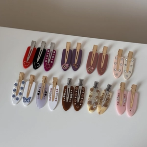 Detailed close-up of colorful marble acetate hair clips with rhinestones and pearls