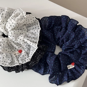 Close-up of handmade polka dot scrunchies with ruffled edges and heart button labels