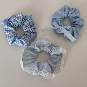 Detail view of blue hair scrunchie set with lace, plaid patterns and bow decorations