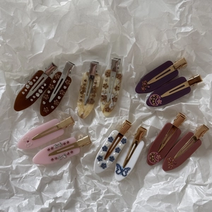 Detail of marble pattern acetate hair clips with rhinestones and pearl embellishments