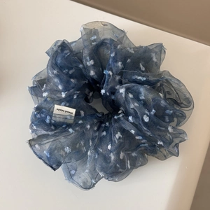 Détail d'un chouchou en mousseline bleu marine à pois blancs avec étiquette Hand Made