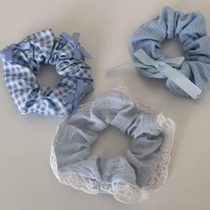 Detailed set of three blue fabric hair scrunchies with plaid patterns and lace trim