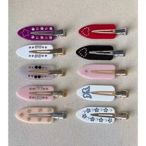 Close-up of marble pattern acetate hair clips with rhinestones in various shapes and colors