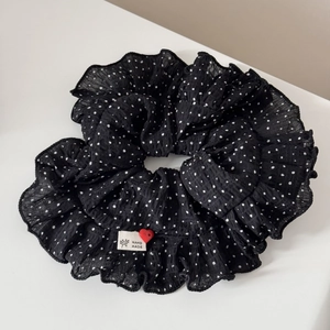 Detail of black polka dot scrunchie with handmade woven label and small red heart button