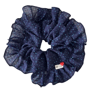 Navy blue polka dot scrunchie with ruffle edges and a small heart bead accent