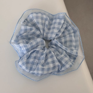 Detail of blue and white gingham hair scrunchie with soft organza pleated edges