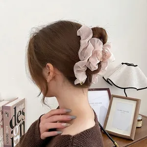 Pince à cheveux en mousseline rose avec pendentif cœur doré portée par un mannequin