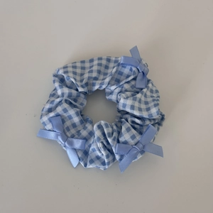 Detailed view of blue checkered scrunchie with soft light blue satin ribbon bows