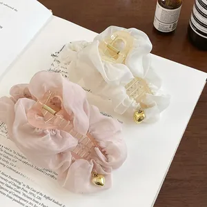 Détail macro de pinces à cheveux en organza rose et blanc avec pendentifs cœur doré