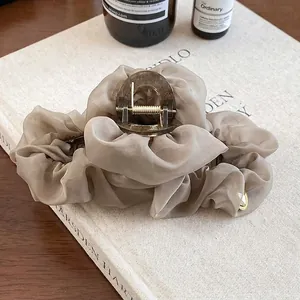 Détail de la pince à cheveux élégante en organza plissé de couleur champagne
