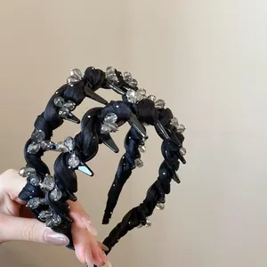 Detail of black twisted satin headband featuring sparkling rhinestones and crystal beads