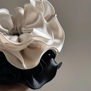Vue macro détaillée des chouchous en satin noir et beige avec texture soyeuse plissée