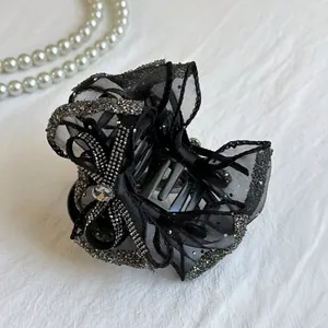 Elegant black mesh bow hair claw clip with rhinestones for a high top hairstyle look