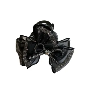Elegant black bow hair claw clip with rhinestones and crystals on white background