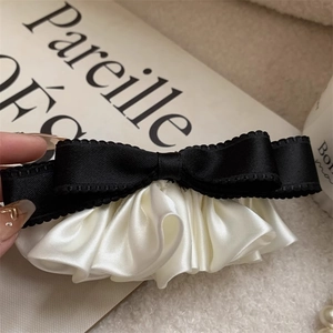 Elegant black and white satin ribbon bow hair clip with ruffled texture and spring clip