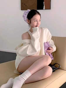 Asian model wearing a purple pleated hair scrunchie and cream white off-shoulder lounge set
