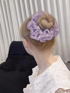 Detailed view of a lavender organza scrunchie styled on a classic hair bun for women