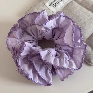 Macro detail of lavender purple scrunchie with heavy pleated ruffles and overlock edge