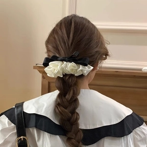 Elegant satin ruffled hair scrunchie with black bow on female model back view