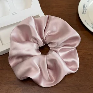Gros plan sur le chouchou en satin rose élégant montrant une texture soyeuse et des plis