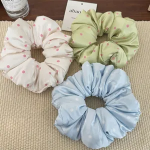 Silk polka dot scrunchie set in cream, light green and blue on woven mat