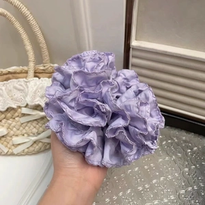 Detail shot showing the rich layers and wavy edges of a light purple pleated scrunchie