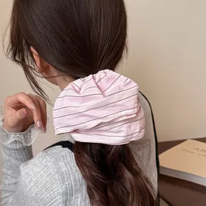 Pink striped oversized hair scrunchie shown in a stylish ponytail on a female model