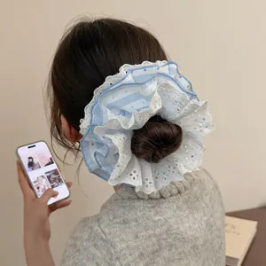 Detail of blue and white striped lace scrunchie styled on a low bun hairstyle