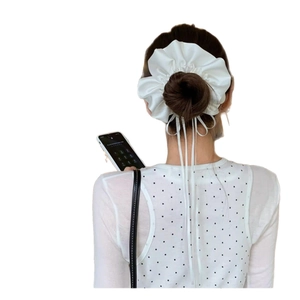 Elegant white satin oversized scrunchie with long ribbons shown on a classic hairstyle