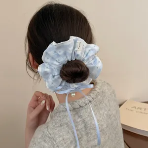 Close-up of blue plaid lace scrunchie featuring a delicate bow and a small pearl pendant