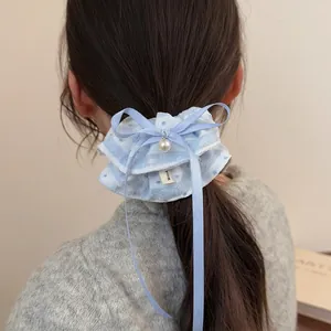 Light blue lace scrunchie with polka dots and a pearl bow pendant on a ponytail
