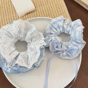 Detail of light blue lace and checkered hair scrunchies with pearls and ribbons