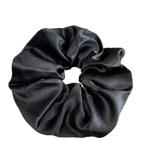 Grand chouchou noir élégant en satin avec finition soyeuse sur fond blanc épuré
