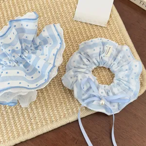 Detail of light blue lace scrunchies with white polka dots and a pearl ribbon bow