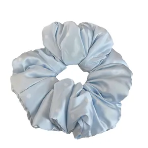 Light blue polka dot hair scrunchie with soft satin texture and pleated design