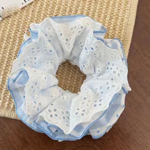 Detail of four-layer lace scrunchie with blue polka dot fabric and floral embroidery