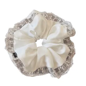 Elegant white silk satin scrunchie with lace trim and Blind for Love label